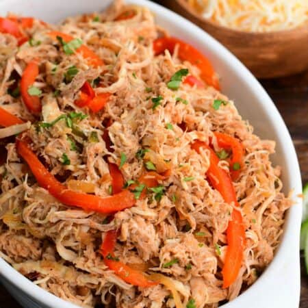 shredded moist and tender salsa chicken mixed with caramelized vegetables in the serving dish.