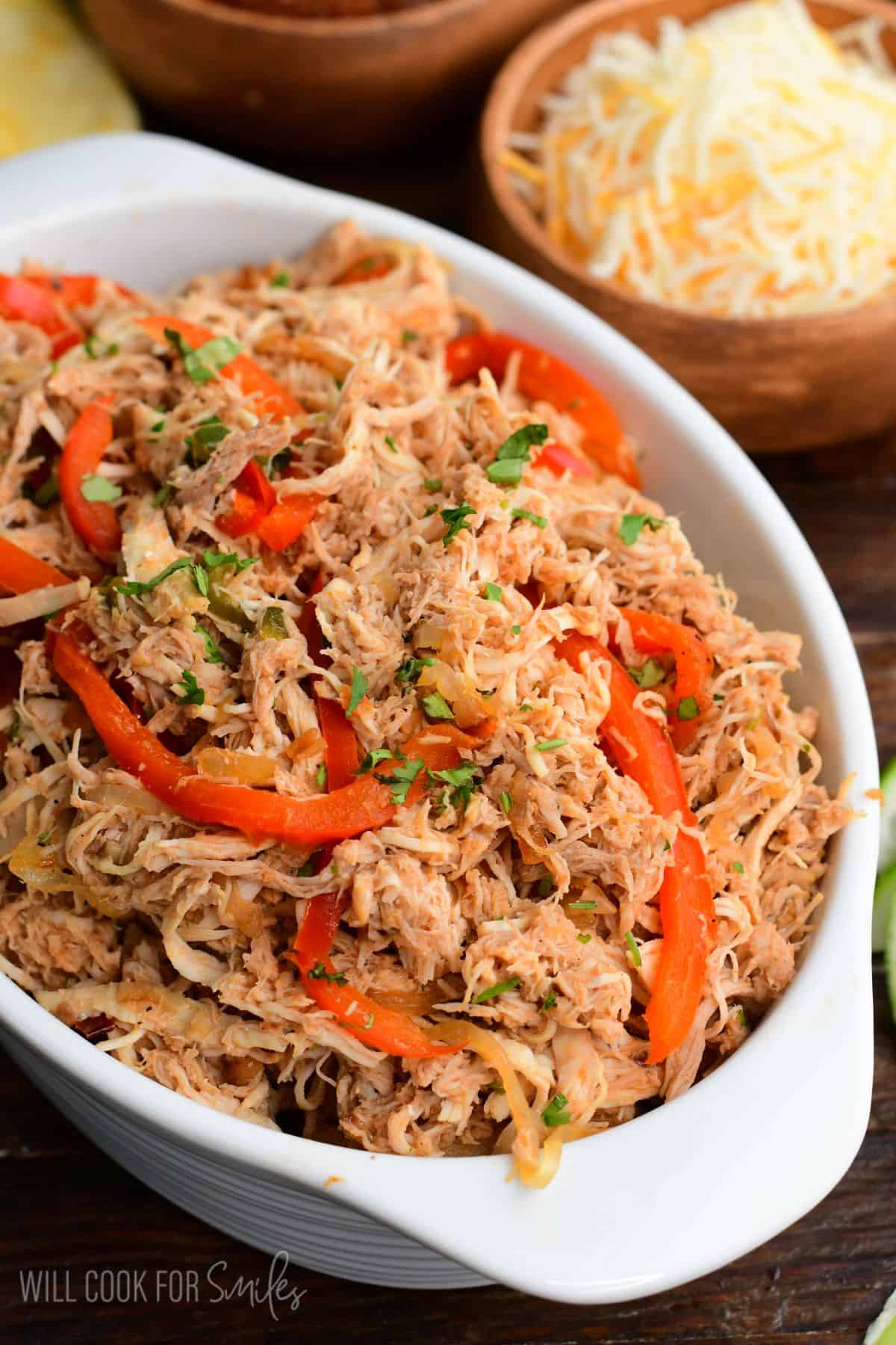 shredded moist and tender salsa chicken mixed with caramelized vegetables in the serving dish.