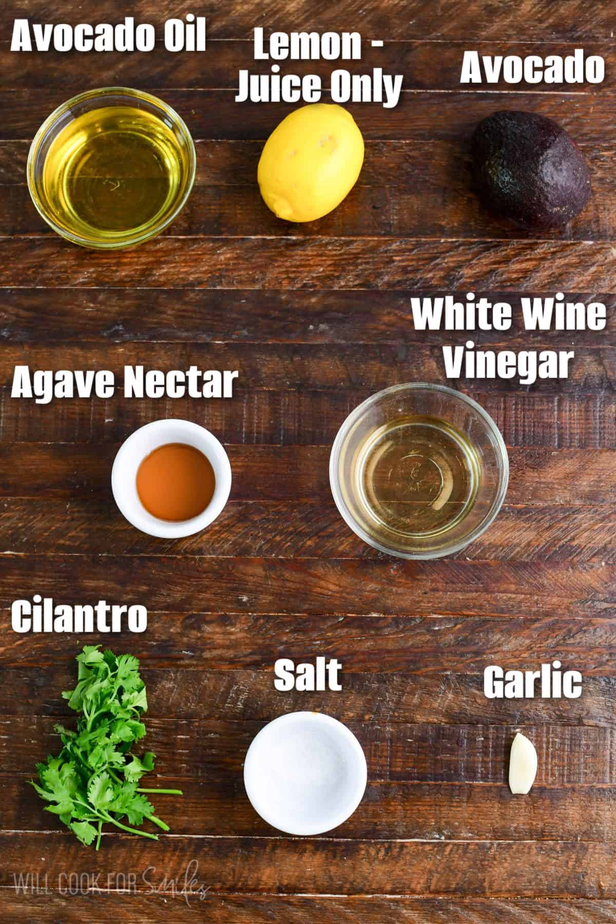 labeled ingredients to make avocado dressing on a wooden board.