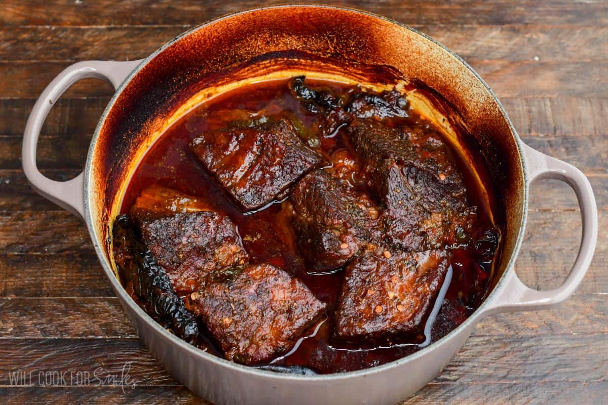 Braised super tender short ribs in chili sauce in a Dutch oven.