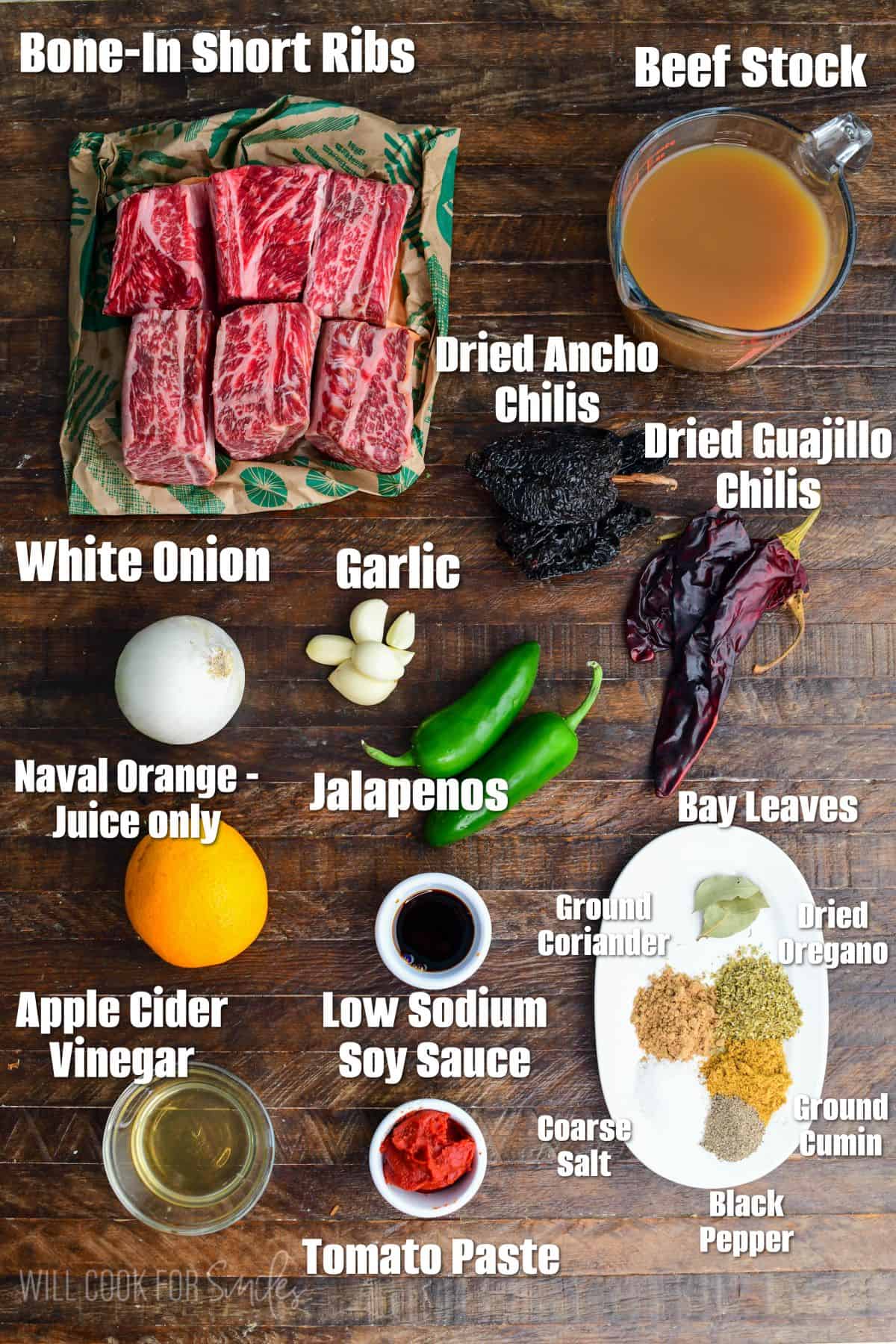 labeled ingredients to make Mexican braised short ribs on wooden board.