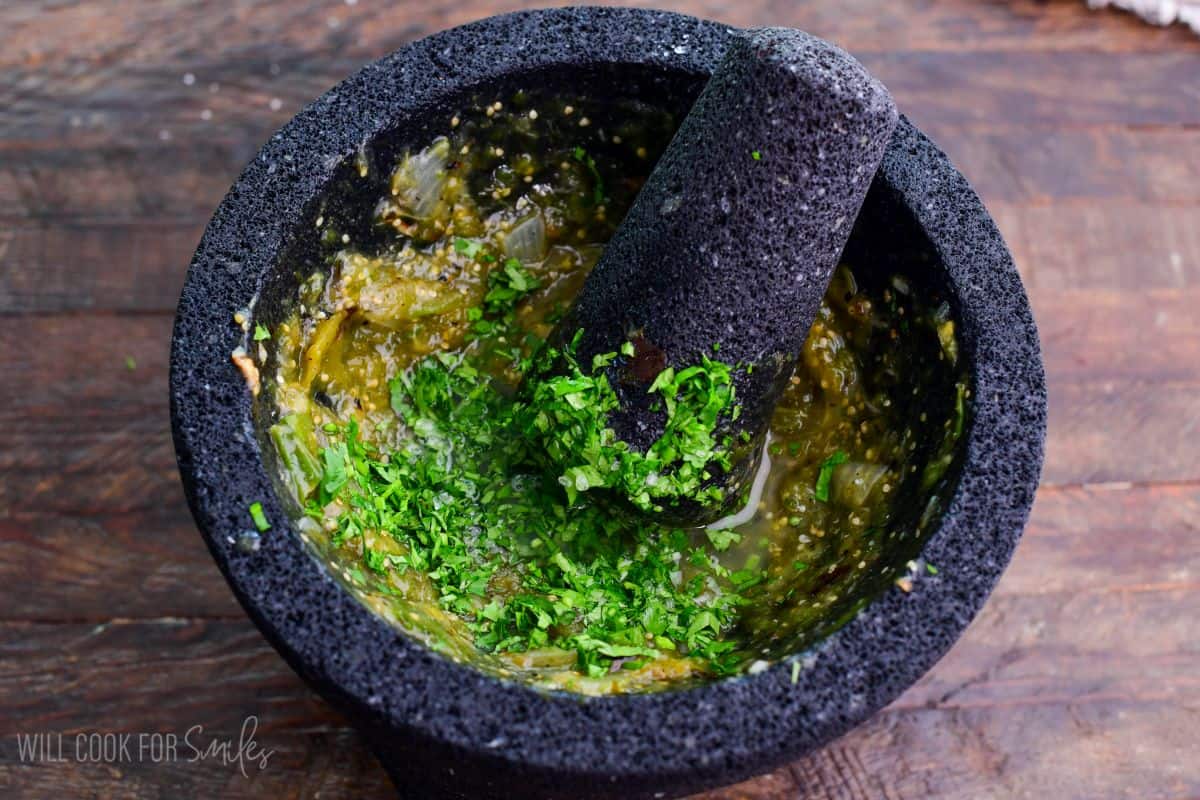 added cilantro and lime juice to salsa verde in molcajete.