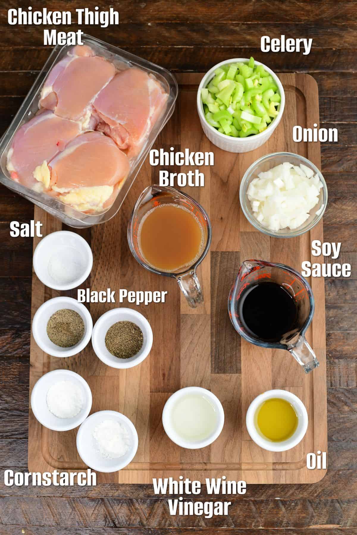 Lableled ingredients for pepper chicken on a wood surface.