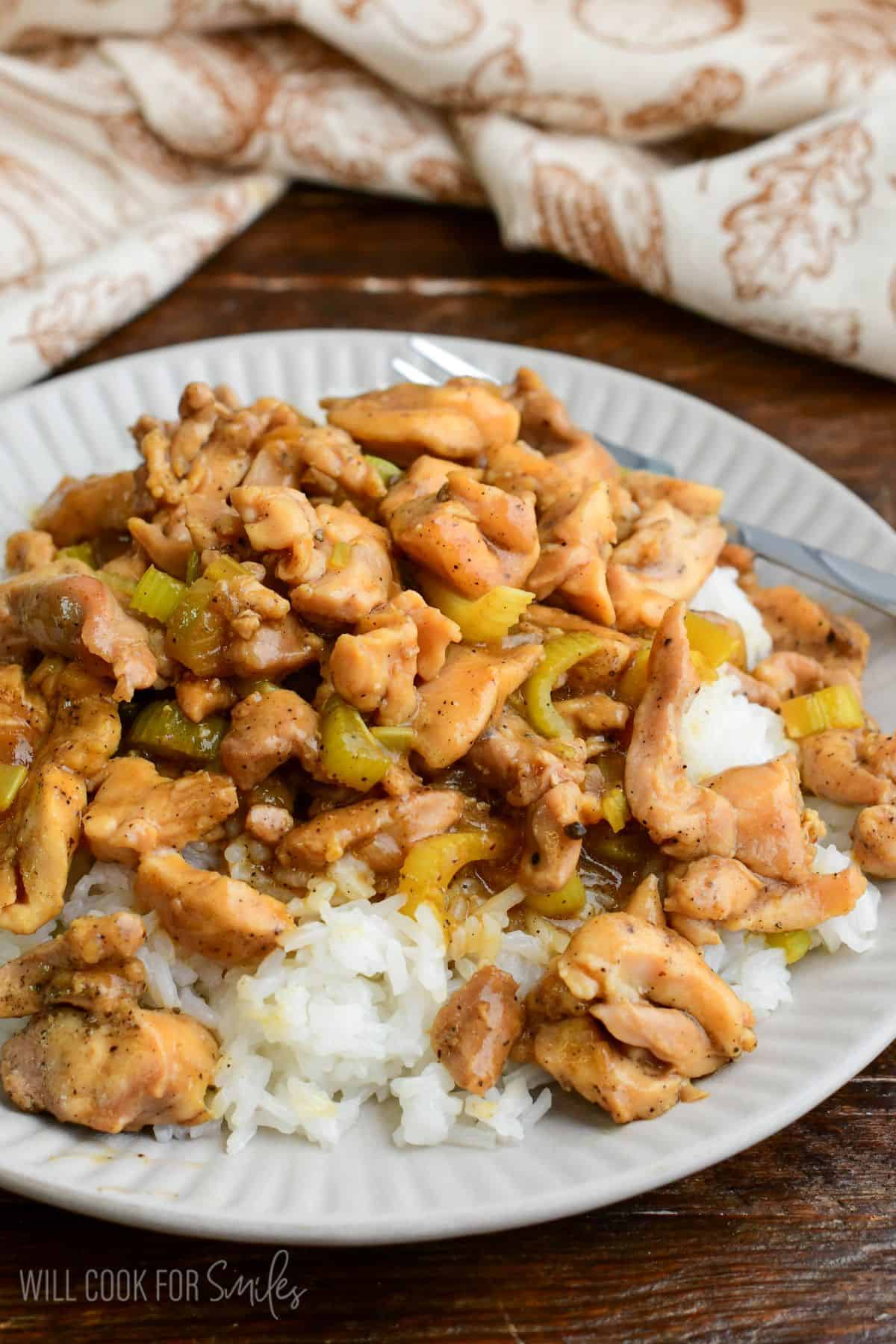 Pepper chicken served over fluffy white rice on a plate.