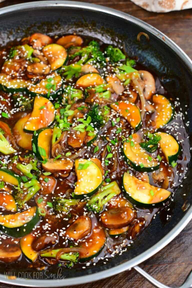 stir fried zucchini and other vegetables in stir fry sauce with sesame seeds and green onion.