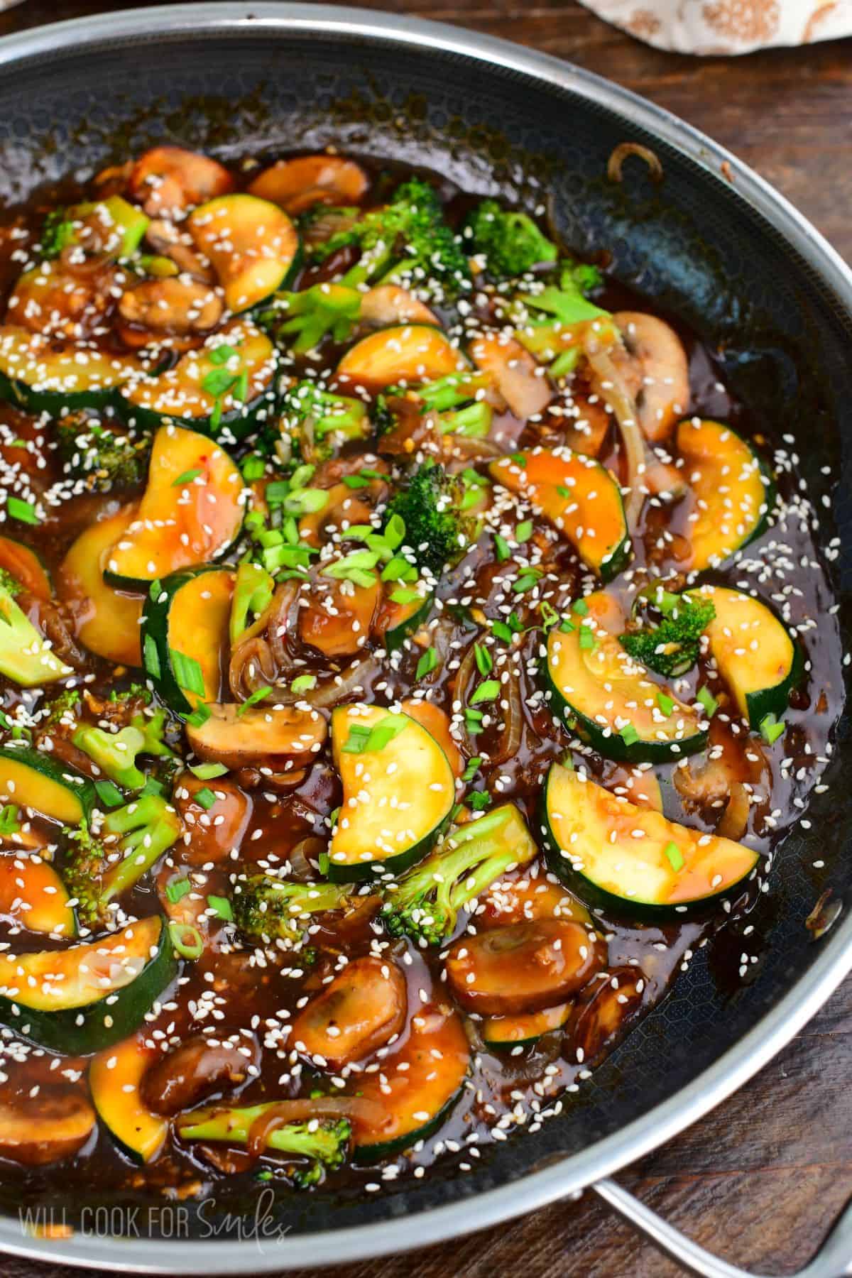 stir fried zucchini and other vegetables in stir fry sauce with sesame seeds and green onion.