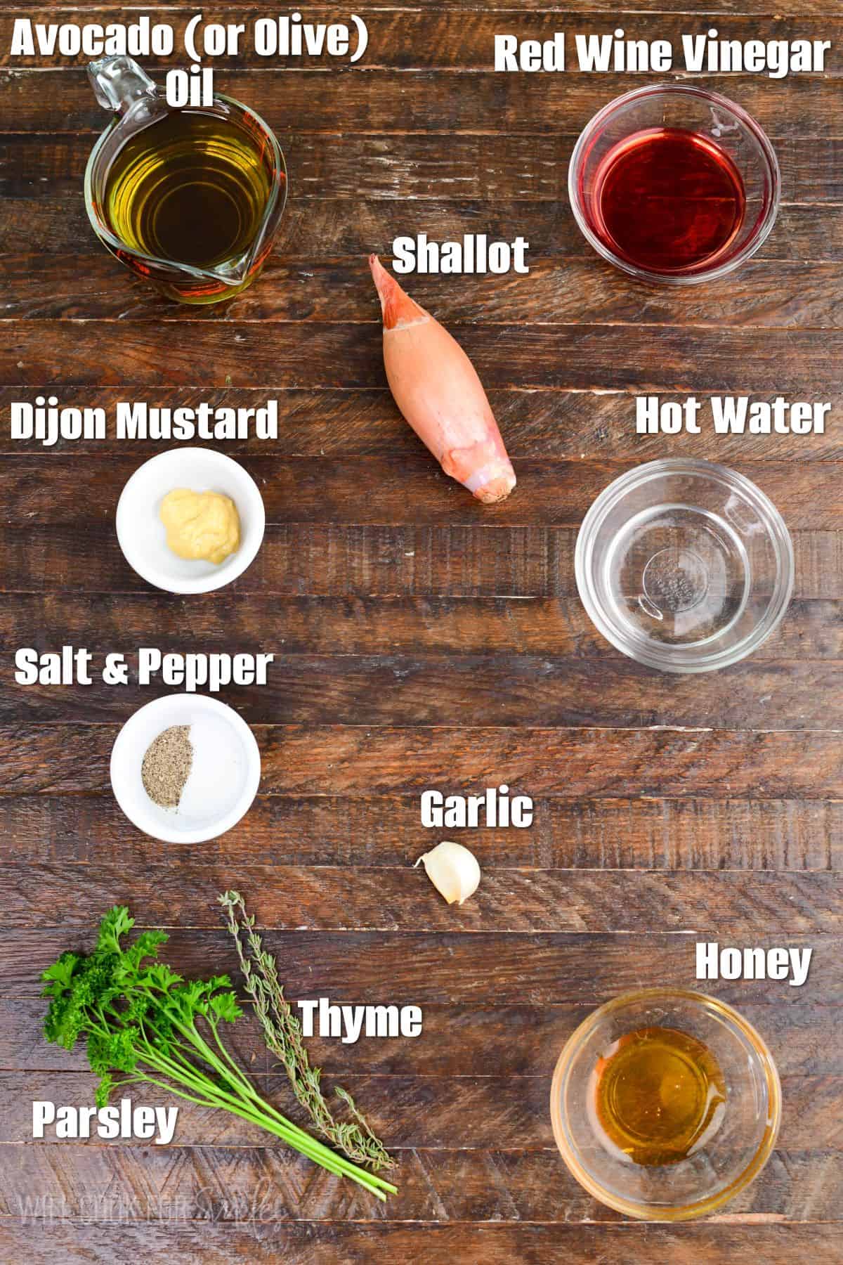 labeled ingredients to make shallot vinaigrette on the wooden background.