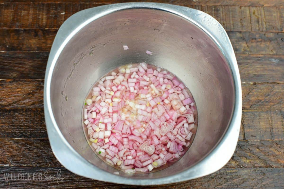 shallots sitting in hot water and vinegar to get the onion sting out.
