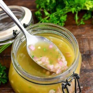 scooping some shallot vinaigrette out of the jar with a spoon.