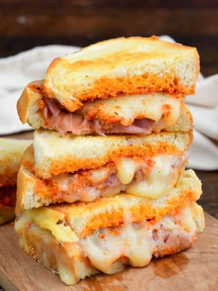 Sun dried tomato pesto grilled cheese sliced and three halves stacked.