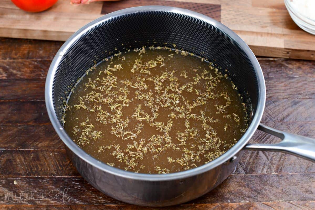 broth mixed with seasoning for the tomato risotto in a pot before heating up.