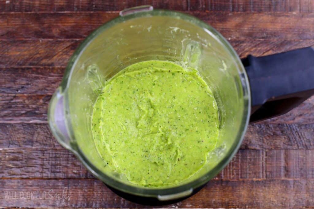 Creamy homemade zucchini pesto blended smooth in a blender.
