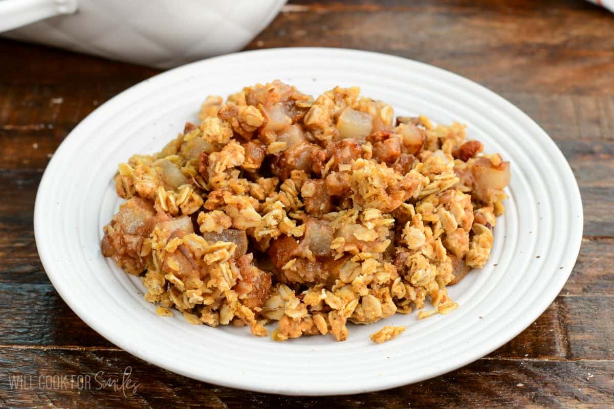 Warm pear crisp with tender spiced pears and a golden oat and pecan crumble topping served on a plate.