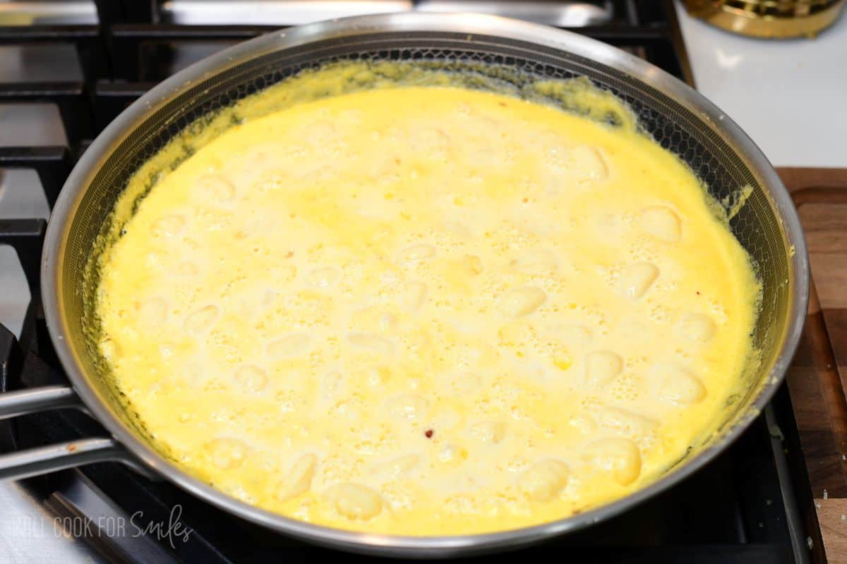 Gnocchi simmering in creamy pumpkin Alfredo sauce until tender and the sauce thickens.
