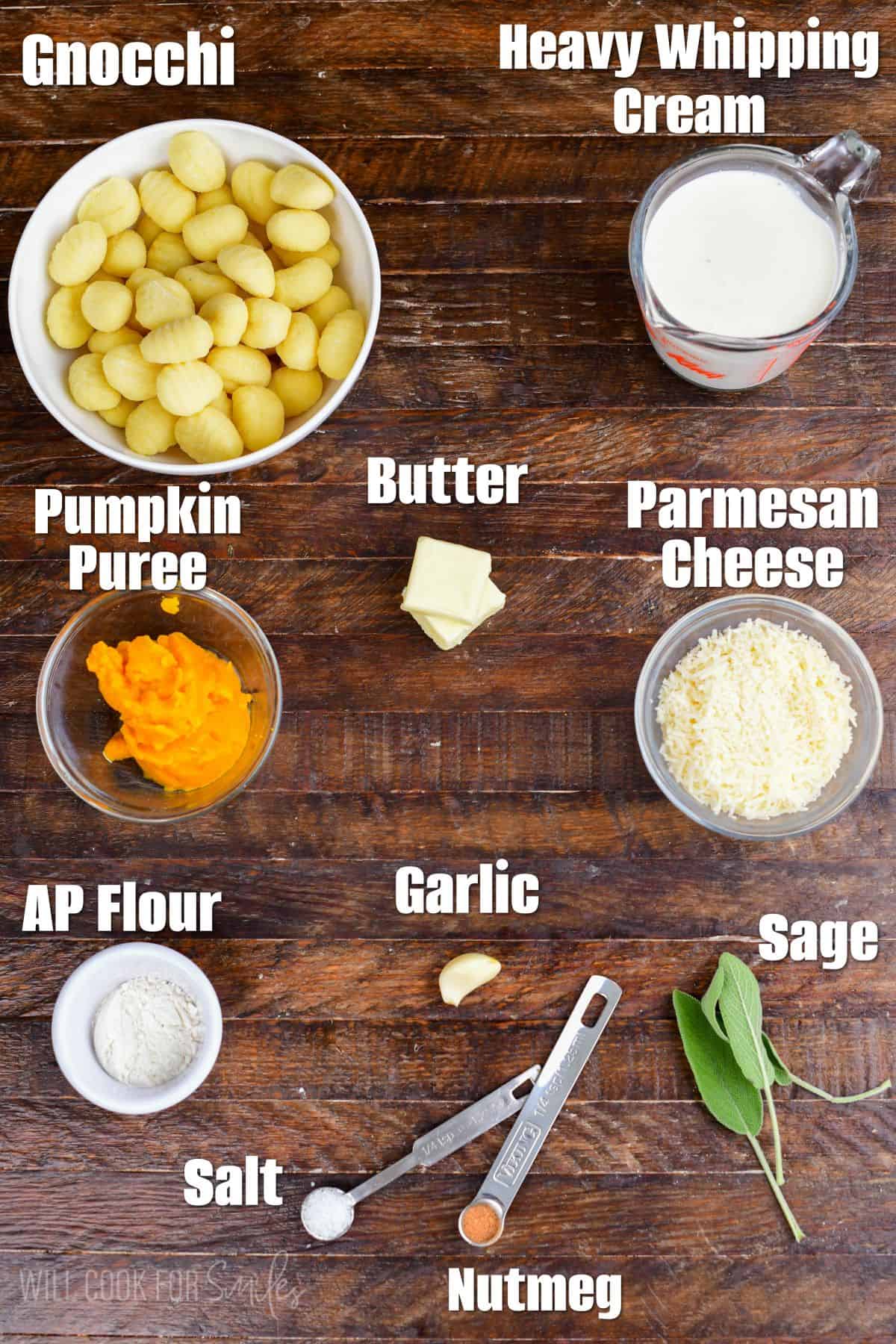 Labeled pumpkin alfredo gnocchi ingredients on a wood surface.