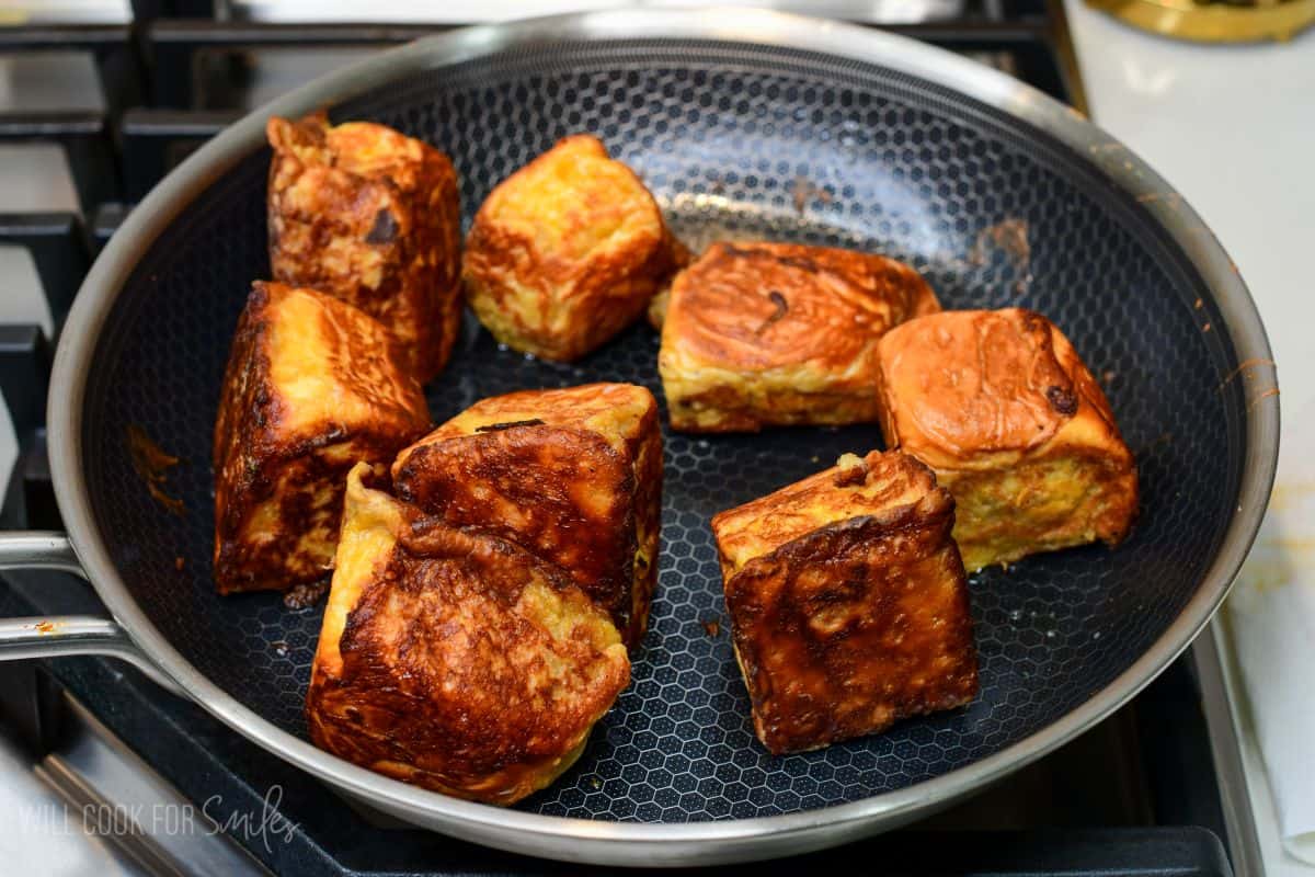 Pumpkin cheesecake stuffed Hawaiian French toast rolls cooked in a skillet until golden brown on all sides.