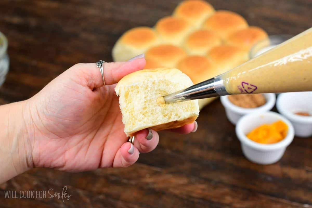 Pumpkin cheesecake filling piped into a soft Hawaiian roll for pumpkin cheesecake stuffed French toast.