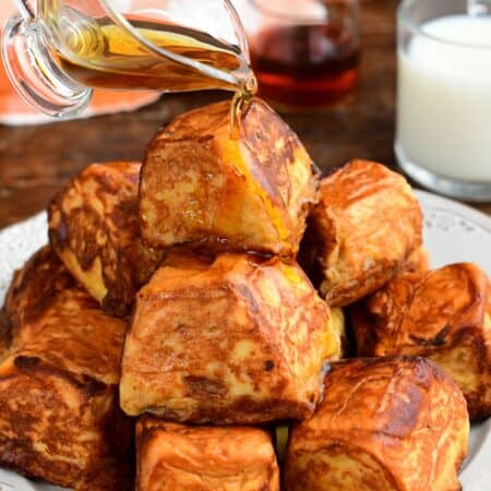 Pumpkin cheesecake stuffed Hawaiian French toast bites drizzled with maple syrup.