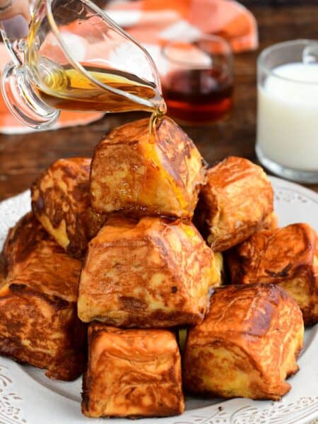 Pumpkin cheesecake stuffed Hawaiian French toast bites drizzled with maple syrup.
