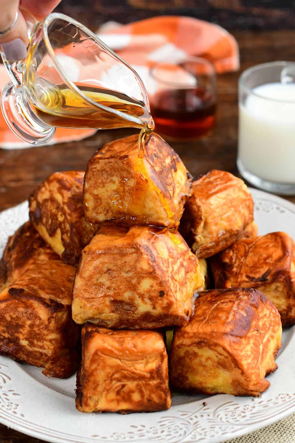 Pumpkin cheesecake stuffed Hawaiian French toast bites drizzled with maple syrup.